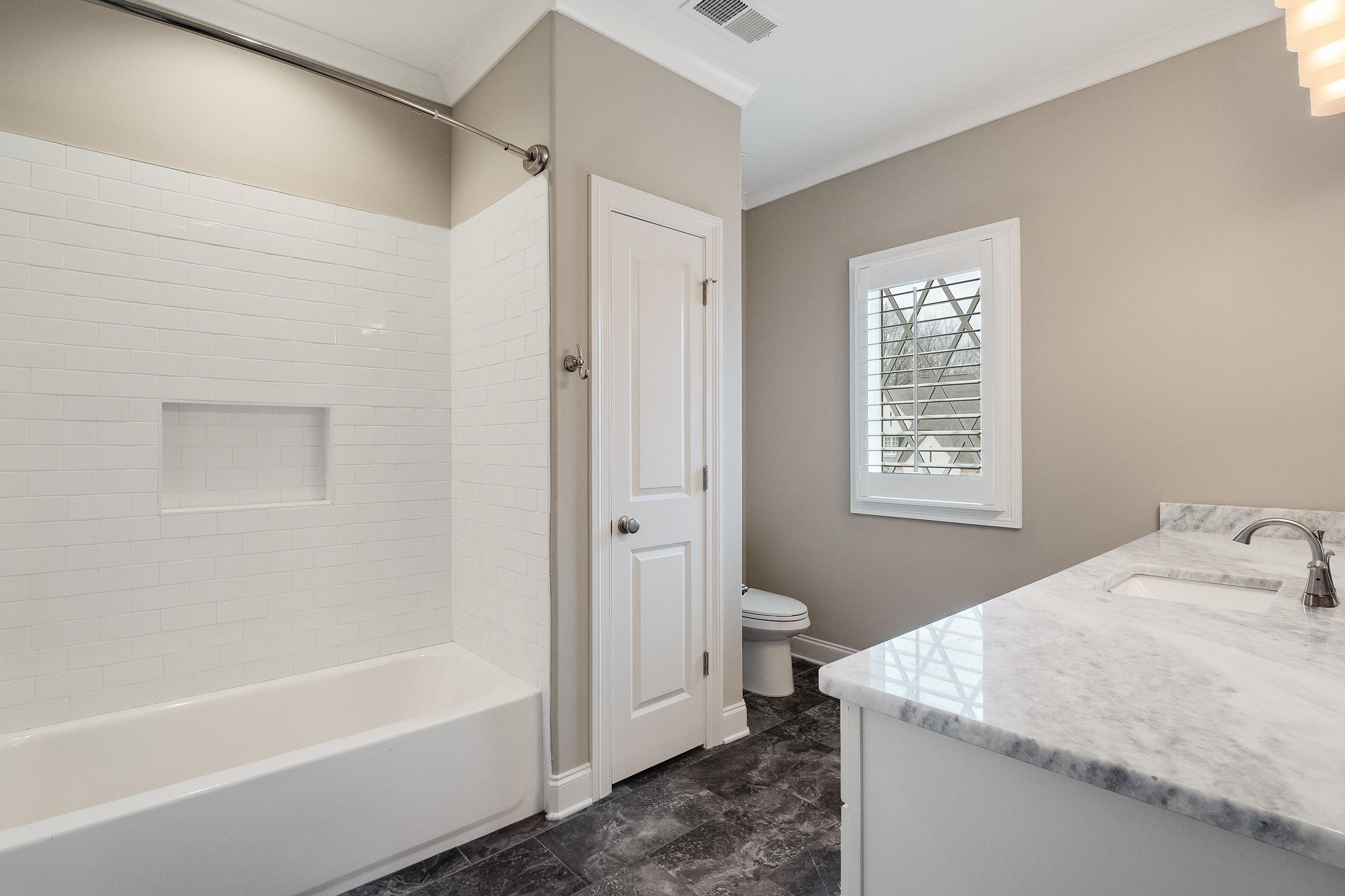 47 Addiegreen Cove Collierville, TN 38017 - Photo 22 of 34 a bathroom with a granite countertop sink a toilet and bathtub