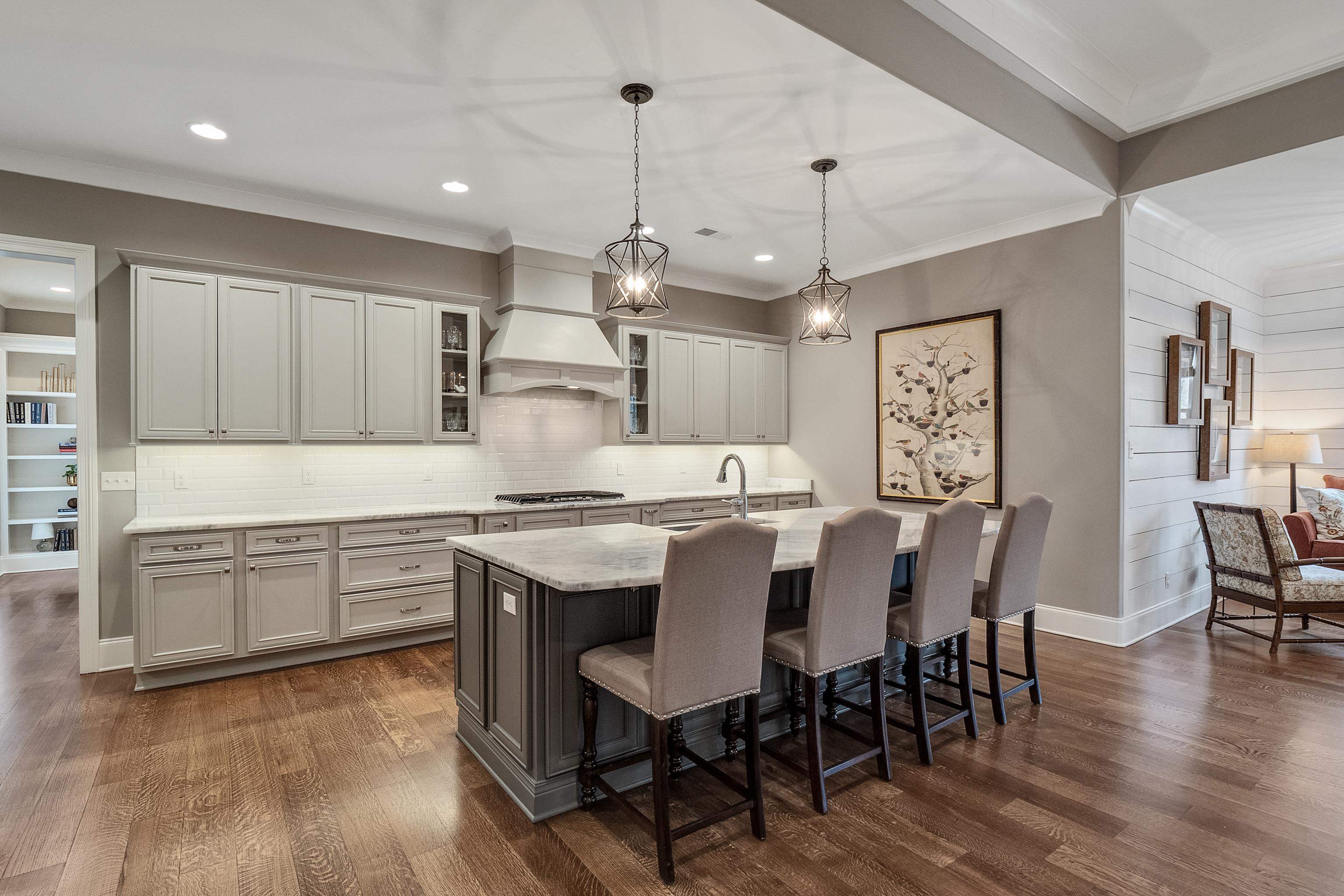 47 Addiegreen Cove Collierville, TN 38017 - Photo 7 of 34 a kitchen with a dining table chairs wooden floor cabinets and stainless steel appliances