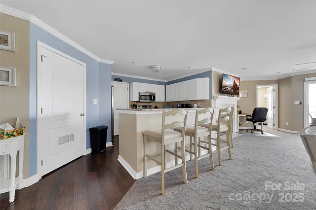 a kitchen with granite countertop a sink white cabinets and wooden floor