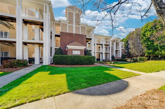 a view of a big building with a big yard and large trees