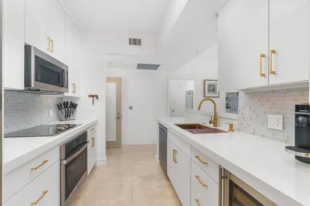 a kitchen with stainless steel appliances granite countertop a sink and stove top oven