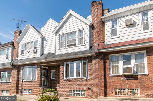 a view of a brick house with large windows