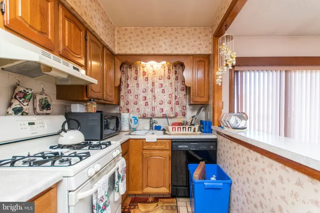 a view of kitchen with stainless steel appliances kitchen island granite countertop a stove a sink and a refrigerator