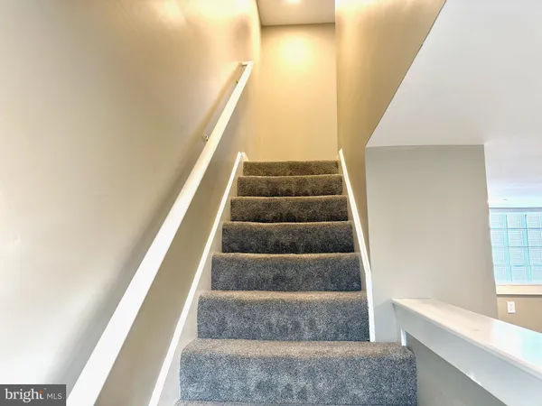 a view of staircase with white walls and windows