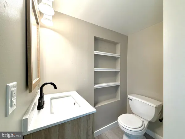 a bathroom with a toilet sink and mirror