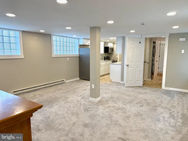 a view of a kitchen with refrigerator and white cabinets