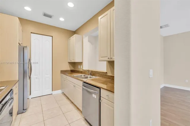 a kitchen with stainless steel appliances granite countertop a refrigerator and a stove top oven