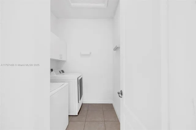 a utility room with cabinets washer and dryer
