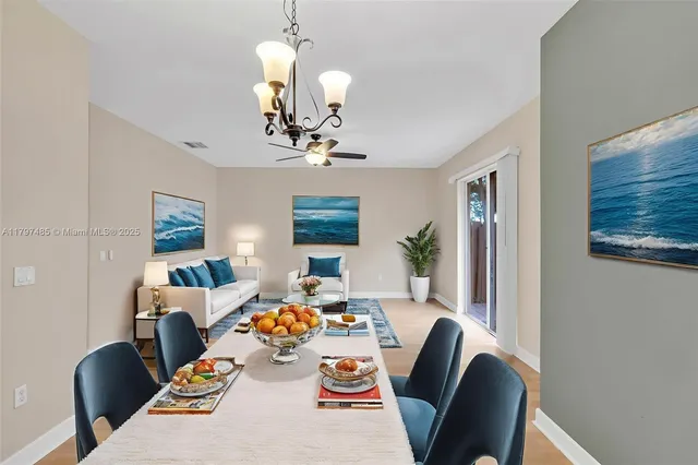 a view of a dining room with furniture a chandelier and wooden floor