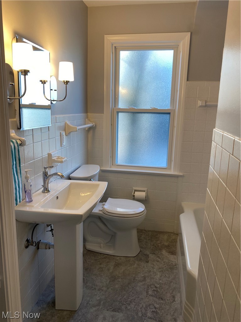 1147 Richmond Road Cleveland, OH 44124 - Photo 12 of 28 Bathroom with a healthy amount of sunlight, tile flooring, tile walls, and toilet