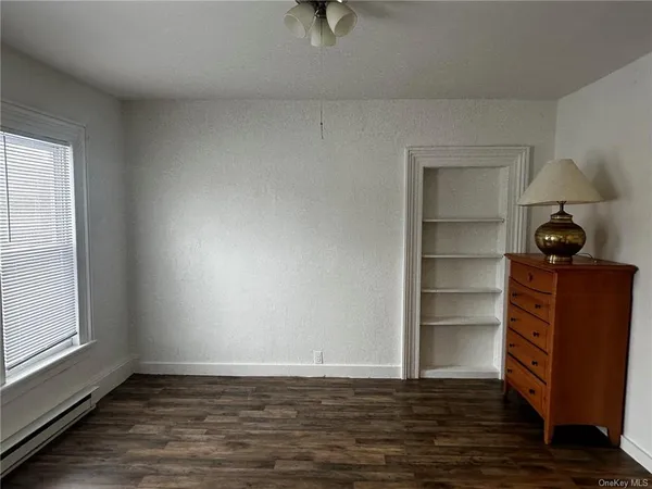 a view of a room with wooden floor and cabinet
