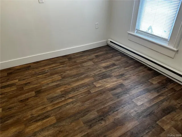 a view of a room with wooden floor and window