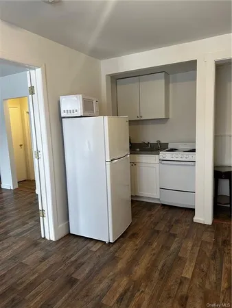 a kitchen with wooden floors and white appliances