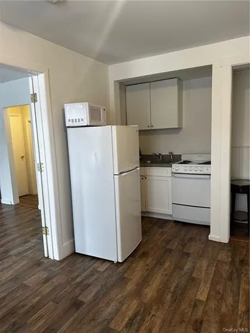 a kitchen with wooden floors and white appliances