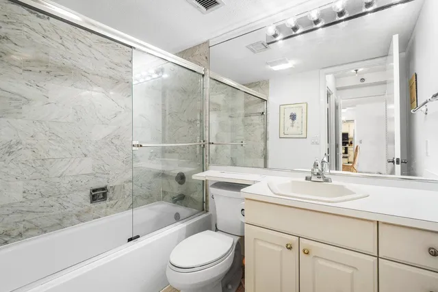 a bathroom with a sink vanity granite toilet tub and shower