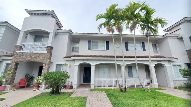 a front view of a house with a garden and plants