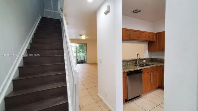 an empty room with wooden floor and a ceiling fan