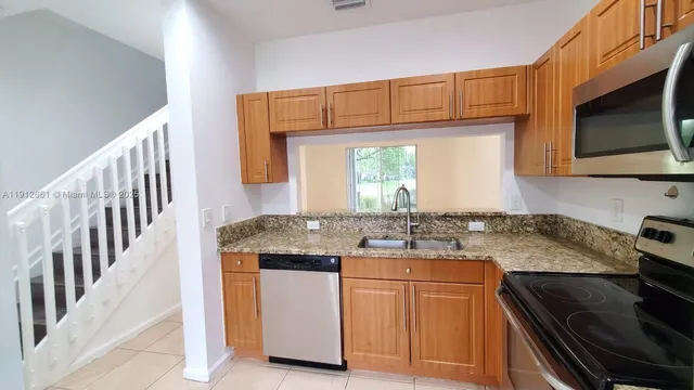 a kitchen with a refrigerator sink and cabinets