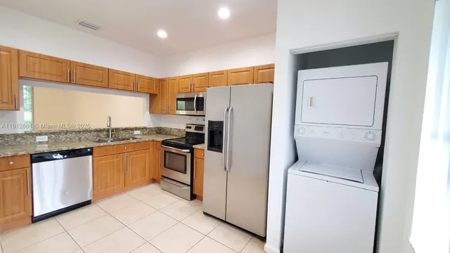 a kitchen with stainless steel appliances granite countertop a refrigerator and a stove