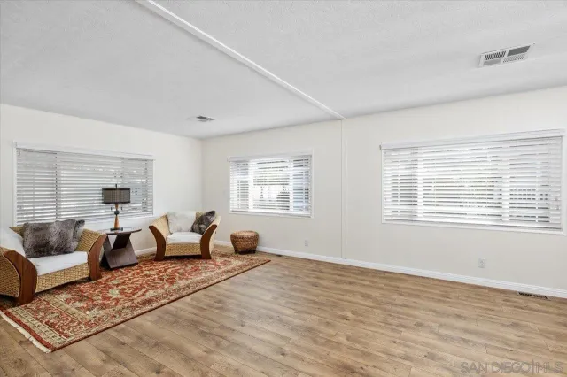 a living room with furniture and two large window