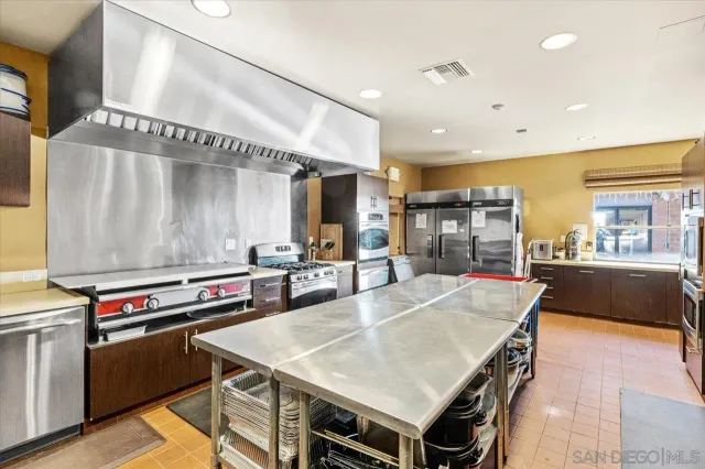 a kitchen with stainless steel appliances a stove a sink and a refrigerator