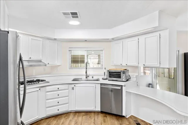 a kitchen with stainless steel appliances a stove sink and cabinets