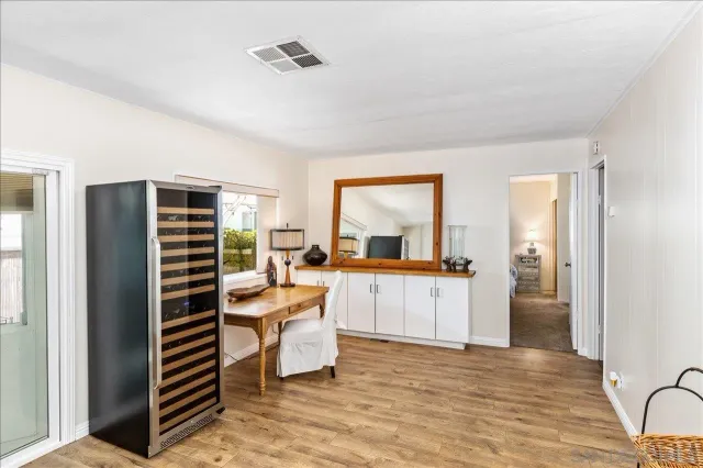 a view of a kitchen with kitchen island stainless steel appliances wooden floor and view living room