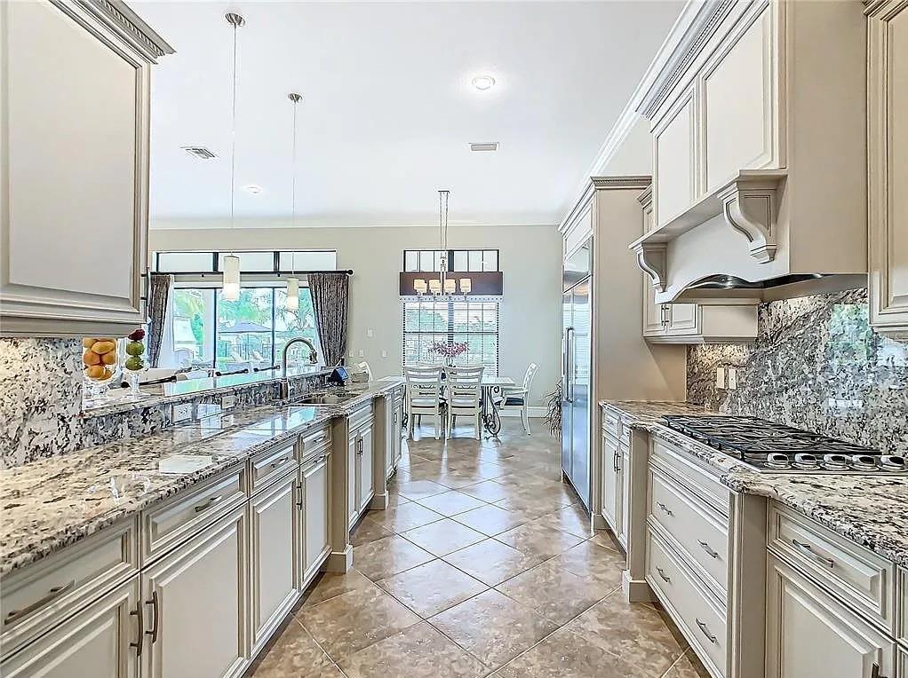 395 Muirfield Loop Reunion, FL 34747 - Photo 12 of 50 a kitchen with stainless steel appliances granite countertop a sink and cabinets