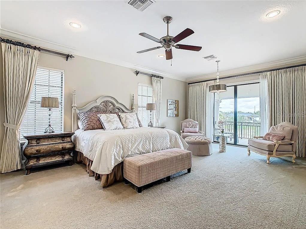 395 Muirfield Loop Reunion, FL 34747 - Photo 14 of 50 a bedroom with a bed a couch and a large window