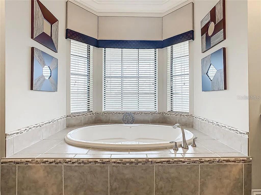 395 Muirfield Loop Reunion, FL 34747 - Photo 21 of 50 a bathroom with a granite countertop sink and a bathtub