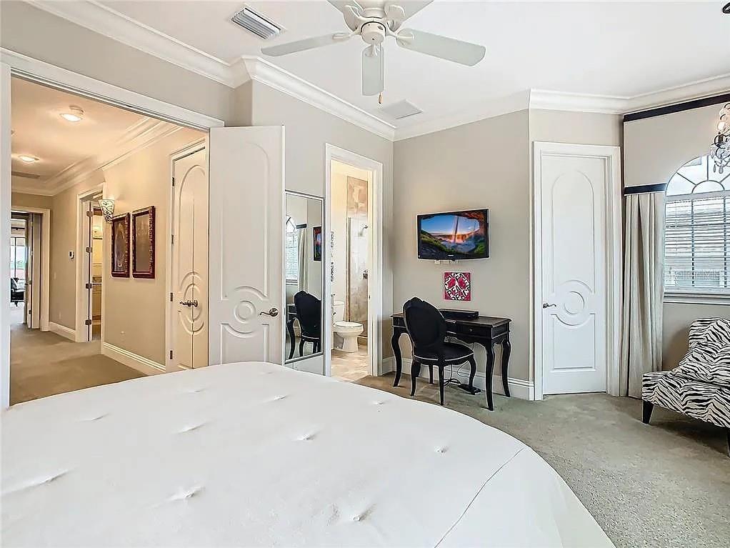 395 Muirfield Loop Reunion, FL 34747 - Photo 25 of 50 a bedroom with a bed and a chandelier