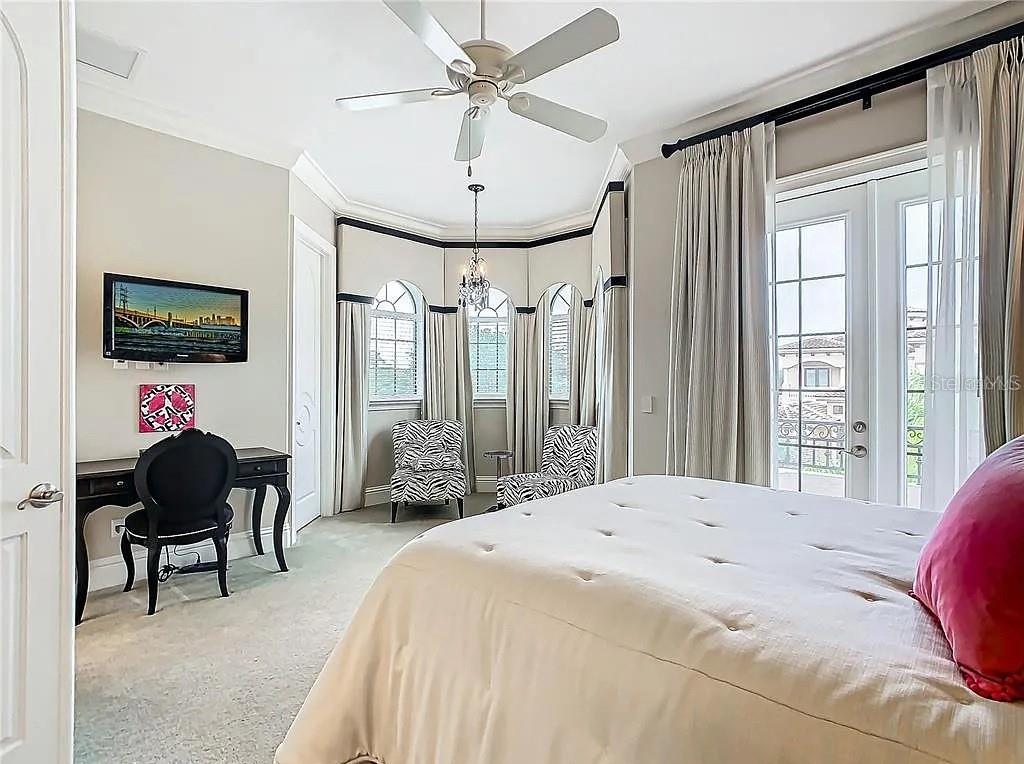 395 Muirfield Loop Reunion, FL 34747 - Photo 27 of 50 a bedroom with a bed and a chandelier
