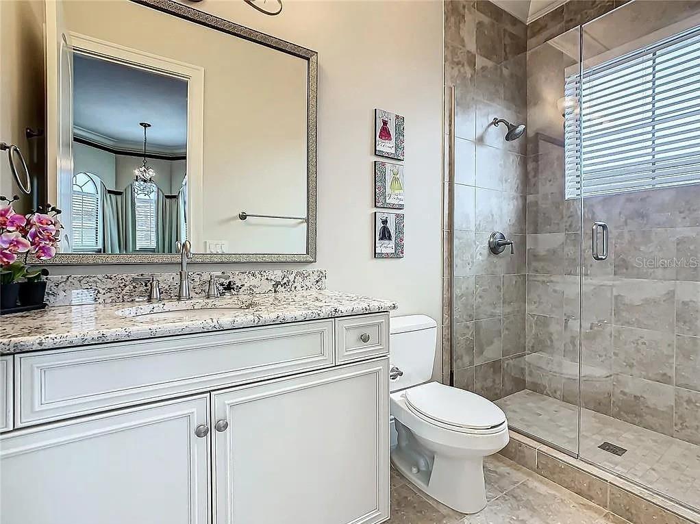 395 Muirfield Loop Reunion, FL 34747 - Photo 28 of 50 a bathroom with a granite countertop sink a toilet and a mirror