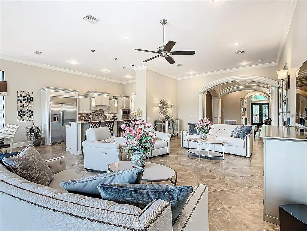 395 Muirfield Loop Reunion, FL 34747 - Photo 10 of 50 a living room with furniture kitchen view and a chandelier