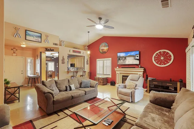 a living room with furniture a clock on wall and a large window