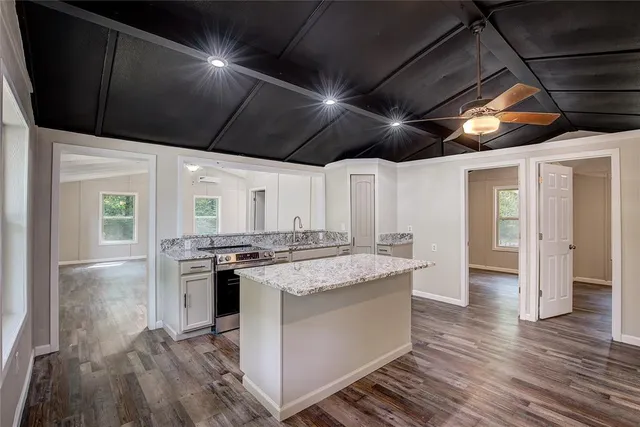 a kitchen with granite countertop cabinets stainless steel appliances and a chandelier