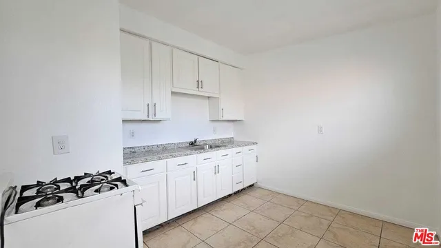 a kitchen with granite countertop white cabinets and white appliances