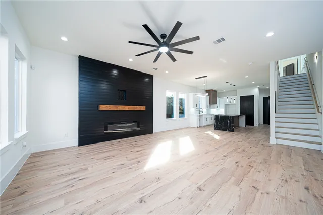 a large white kitchen with a large counter top a sink a stove and a refrigerator