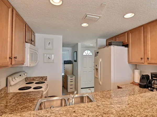 a kitchen with a sink stove top oven and cabinets