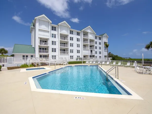 a view of a swimming pool with a lawn chairs and plants