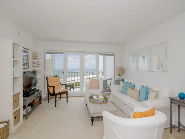 a living room with furniture a flat screen tv and a floor to ceiling window