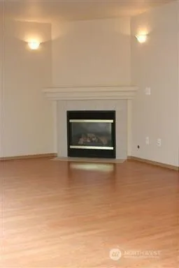 an empty room with wooden floor and mirror