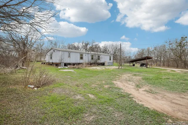 a backyard of a house with table and chairs