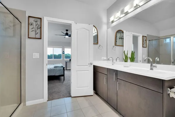 a en suite bathroom with a double vanity sink a mirror and shower
