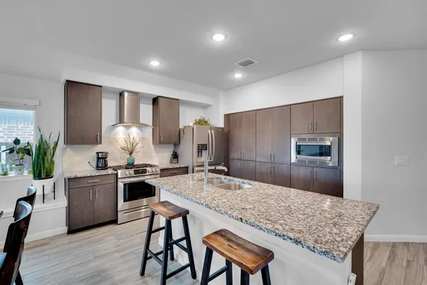 a kitchen with granite countertop kitchen island wooden cabinets and stainless steel appliances