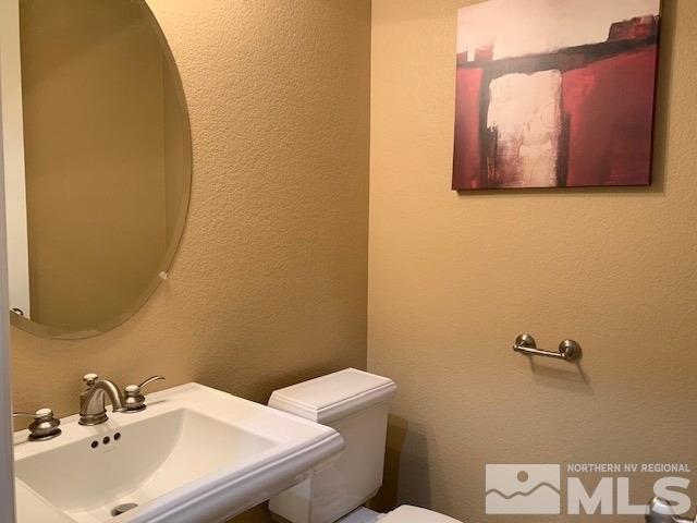 8380 Cinnamon Ridge Lane Reno, NV 89523 - Photo 10 of 17 a bathroom with a sink a toilet and mirror