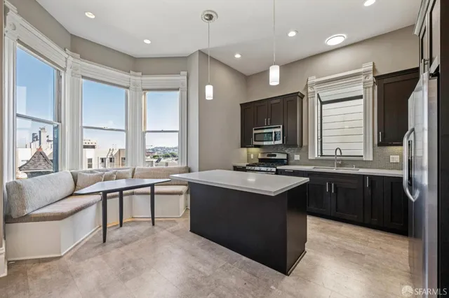 a large kitchen with kitchen island a sink stainless steel appliances and cabinets