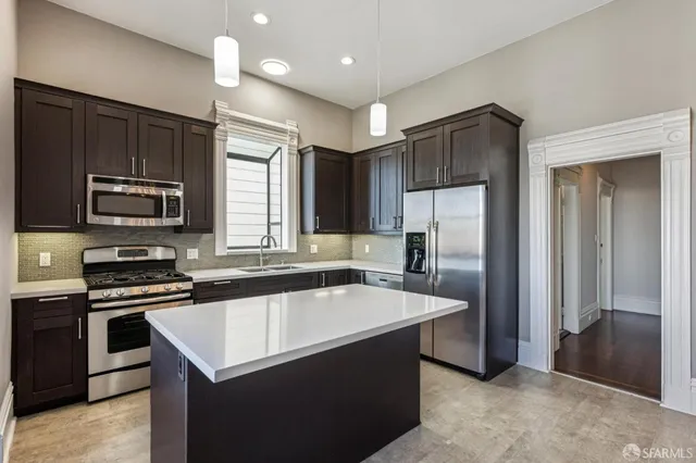 a kitchen with a refrigerator a sink and wooden cabinets