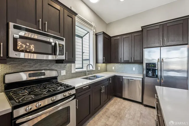 a kitchen with stainless steel appliances granite countertop a stove microwave and sink