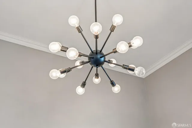 a view of room with table and a chandelier fan